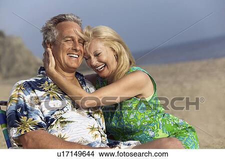 Picture - Couple relaxing on beach. Fotosearch