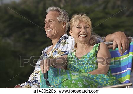 Stock Photography - Couple relaxing outdoors, smiling. Fotosearch