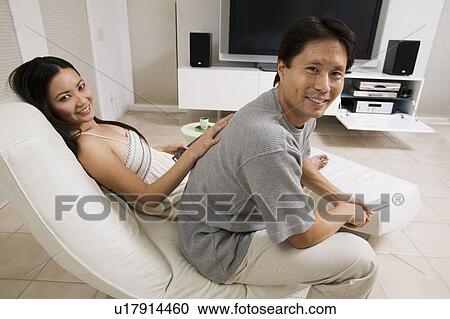 Stock Image - Couple sitting in Living Room Together, portrait. Fotosearch