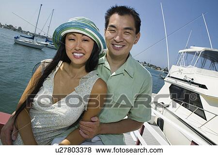 Stock Photo - Couple smiling at marina, (portrait). Fotosearch
