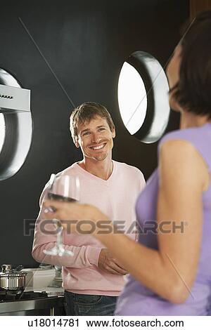 Couple talking in modern kitchen, half length View Large Photo Image Stock Image - Couple talking in modern kitchen, half length. Fotosearch