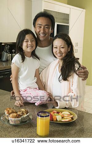 Stock Image - Family at kitchen table with breakfast, portrait. Fotosearch