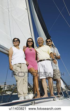 Stock Image - Family on sailboat, (portrait). Fotosearch