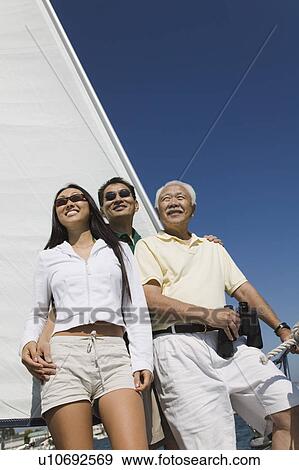 Stock Photo - Family on sailboat, smiling. Fotosearch