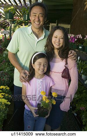 Stock Photo - Family Shopping for Plants in nursery, portrait, front view. Fotosearch