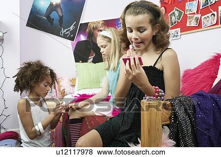 Fashionable Young Girls Applying Makeup in trendy bedroom View Large Photo Image Stock Photo - Fashionable Young Girls Applying Makeup in trendy bedroom. Fotosearch