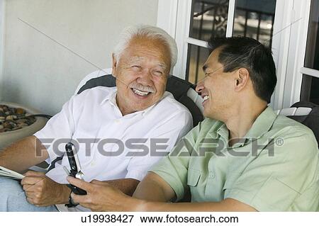 Stock Photo - Father and son laughing outside home. Fotosearch