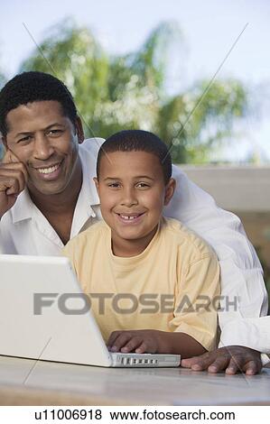 Father and Son sitting on patio Using Laptop, portrait View Large Photo Image Stock Photo - Father and Son sitting on patio Using Laptop, portrait. Fotosearch