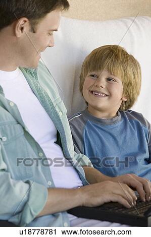 Stock Image - Father and Son Using Laptop Together. Fotosearch