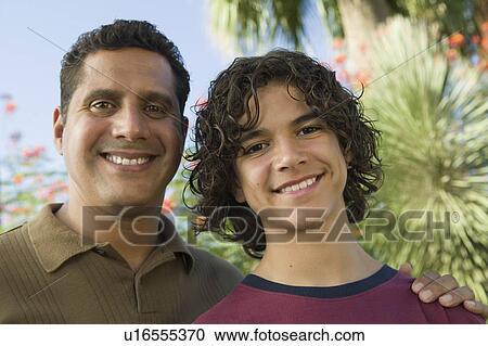 Stock Image - Father with Arm Around Son (13-15), front view portrait.. Fotosearch