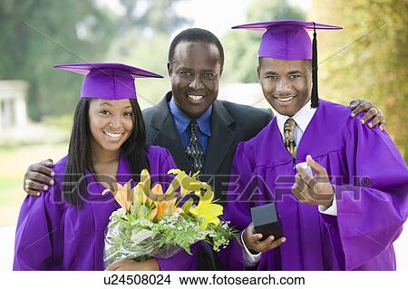 Picture - Father with two graduates outside, portrait. Fotosearch