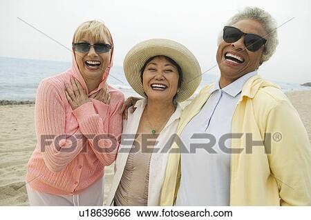 Female friends laughing at beach, (portrait) View Large Photo Image Stock Photograph - Female friends laughing at beach, (portrait). Fotosearch