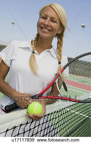 Stock Photo - Female Tennis Player at net on tennis court, portrait. Fotosearch
