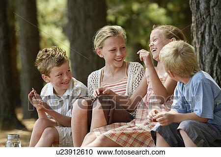 Four children (7-9) sitting in forest, laughing. View Large Photo Image Stock Image - Four children (7-9) sitting in forest, laughing.. Fotosearch