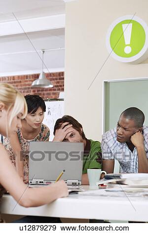 Four people having meeting around laptop. View Large Photo Image Stock Photo - Four people having meeting around laptop.. Fotosearch