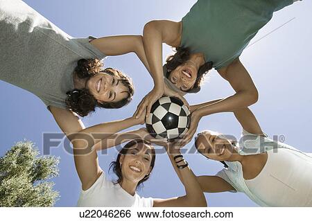 Four women holding soccer ball together, view from below. View Large Photo Image Stock Photograph - Four women holding soccer ball together, view from below.. Fotosearch