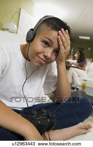 Stock Image - Frustrated Boy with Headphones Playing Video Game. Fotosearch
