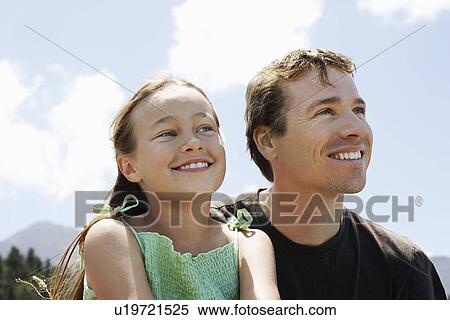 Girl (7-9) sitting outdoors with father. View Large Photo Image Stock Photography - Girl (7-9) sitting outdoors with father.. Fotosearch