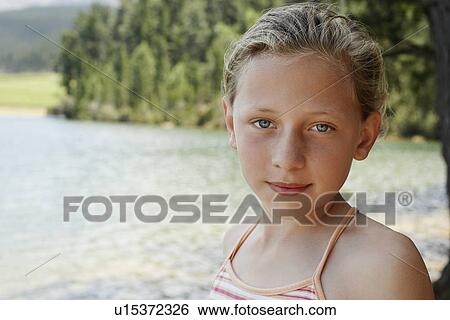 Girl (7-9) standing by lake, portrait. View Large Photo Image Stock Photograph - Girl (7-9) standing by lake, portrait.. Fotosearch