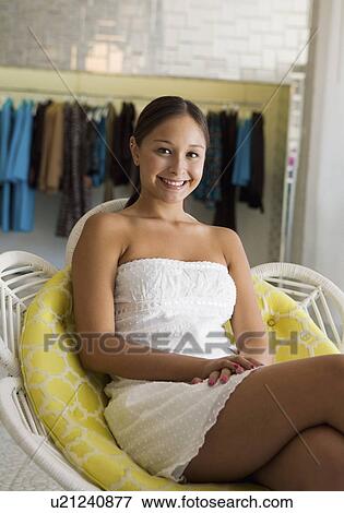 Girl Relaxing on chair in Clothing Boutique, portrait View Large Photo Image Stock Photo - Girl Relaxing on chair in Clothing Boutique, portrait. Fotosearch