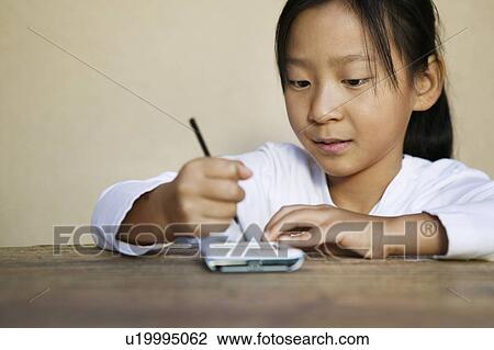 Girl using PDA View Large Photo Image Stock Image - Girl using PDA. Fotosearch