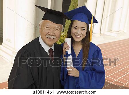 Stock Image - Graduate and dean outside university, elevated view, portrait. Fotosearch