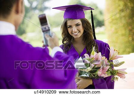 Graduate Having Picture Taken with Cell Phone outside View Large Photo Image Stock Photo - Graduate Having Picture Taken with Cell Phone outside. Fotosearch