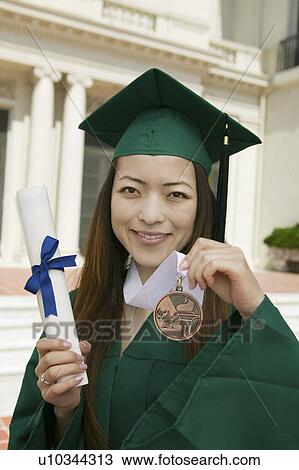 Graduate holding diploma and medal outside university, portrait View Large Photo Image Stock Image - Graduate holding diploma and medal outside university, portrait. Fotosearch