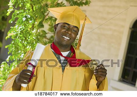 Graduate holding diploma and medal outside, portrait View Large Photo Image Stock Photo - Graduate holding diploma and medal outside, portrait. Fotosearch