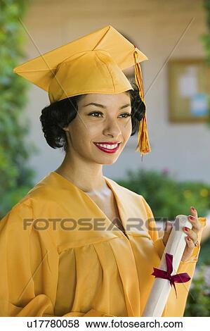 Stock Photo - Graduate holding diploma outside, portrait. Fotosearch