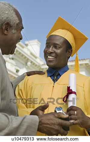 Graduate receiving present from father outside university View Large Photo Image Stock Image - Graduate receiving present from father outside university. Fotosearch