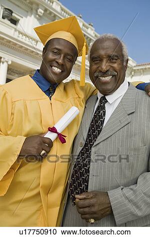 Stock Image - Graduate with father outside university, portrait. Fotosearch