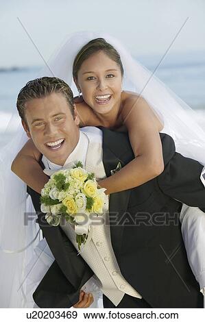 Groom giving Bride piggyback ride, outdoors, (portrait) View Large Photo Image Stock Photo - Groom giving Bride piggyback ride, outdoors, (portrait). Fotosearch