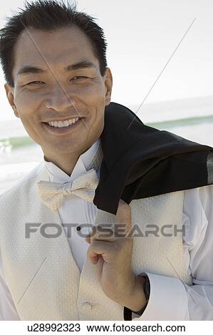 Stock Image - Groom smiling outdoors, (close-up), (portrait). Fotosearch