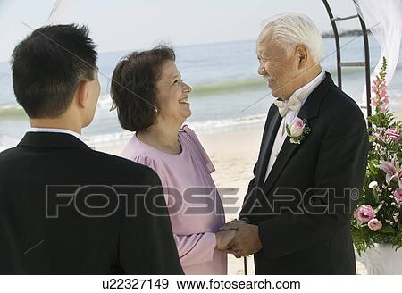 Stock Photo - Groom with parents at beach wedding. Fotosearch