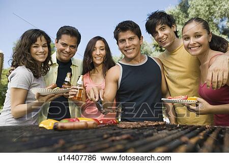 Stock Photograph - Group of young people around outdoor grill.. Fotosearch