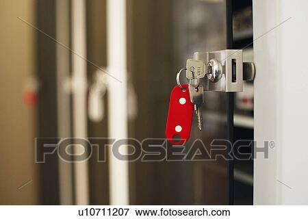 Stock Photo - Keys with red keychain in lock, close-up.. Fotosearch