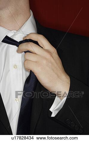 Man adjusting necktie, mid section View Large Photo Image Picture - Man adjusting necktie, mid section. Fotosearch