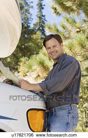 Stock Photograph - Man holding map on RV. Fotosearch