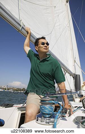 Man on sailboat View Large Photo Image Stock Photo - Man on sailboat. Fotosearch