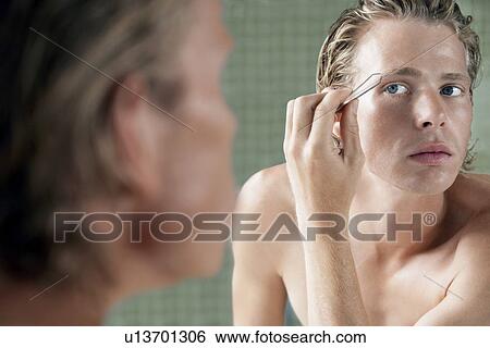 Stock Photograph - Man plucking eyebrows. Fotosearch