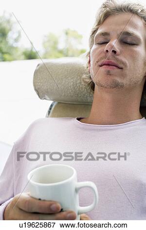 Man relaxing on chaise lounge View Large Photo Image Stock Photo - Man relaxing on chaise lounge. Fotosearch