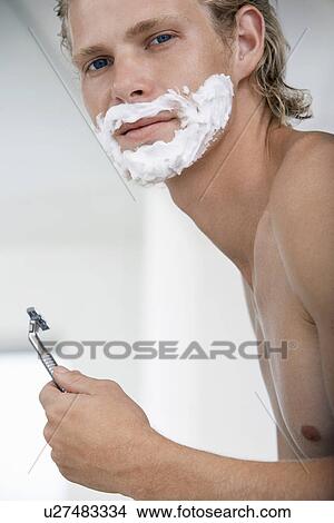 Man shaving face in bathroom, portrait View Large Photo Image Picture - Man shaving face in bathroom, portrait. Fotosearch