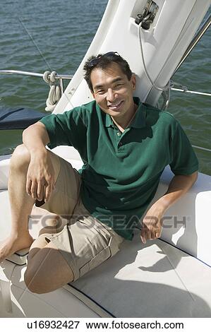 Stock Photo - Man smiling on sailboat, (portrait). Fotosearch