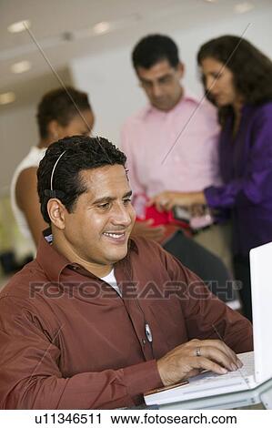 Man using laptop with headset in furniture store View Large Photo Image Stock Image - Man using laptop with headset in furniture store. Fotosearch