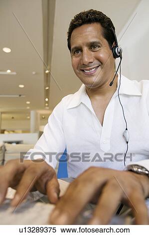 Man with headset Working on Computer in office View Large Photo Image Stock Photography - Man with headset Working on Computer in office. Fotosearch