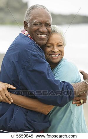 Stock Photography - Mature couple embracing on beach. Fotosearch