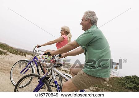 Stock Photo - Middle-aged couple riding bicycles. Fotosearch