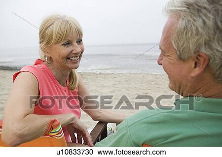 Middle-aged couple sitting on beach View Large Photo Image Stock Image - Middle-aged couple sitting on beach. Fotosearch