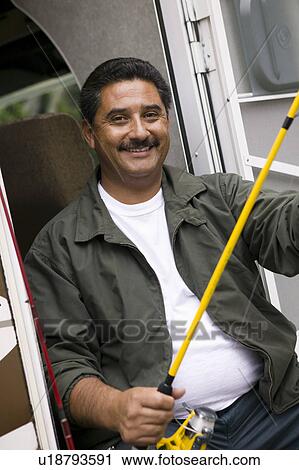 Middle-aged man holding fishing rod View Large Photo Image Stock Image - Middle-aged man holding fishing rod. Fotosearch